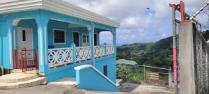 a blue house with a balcony on a hill at Hillcrest Haven in Kingstown