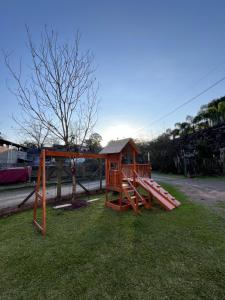 a playground with a play house in the grass at Casa no Vale dos Vinhedos in Bento Gonçalves
