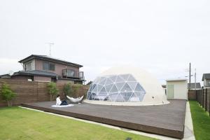 a woman sitting on a deck in a yard with a domed house at EIGHT VILLAGE - Vacation STAY 40435v in Katakai +6 photos