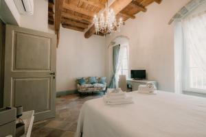 a bedroom with a bed and a chair and a chandelier at Dimora Lucia - Camere Relax con bagno privato in Fossombrone