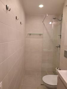 a white bathroom with a shower and a toilet at Comfortable Apartment Gerbera Tallinn in Tallinn +17 photos