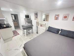 a white bedroom with a bed and a table at Charmant studio neuf et meublé in Gagny