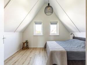 Un dormitorio con una cama y dos ventanas. en Holiday Home in Scherpenisse near Oosterschelde, en Scherpenisse