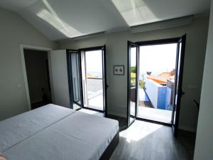 Schlafzimmer mit einem Bett und Glasschiebetüren in der Unterkunft Casa das Andorinhas in Estreito da Calheta + 33 Fotos