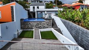 eine Treppe, die zu einem Haus mit Swimmingpool führt in der Unterkunft Casa das Andorinhas in Estreito da Calheta