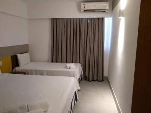 een hotelkamer met twee bedden en een raam bij Apartamento dentro de um Resort 6 in Olímpia +8 foto's