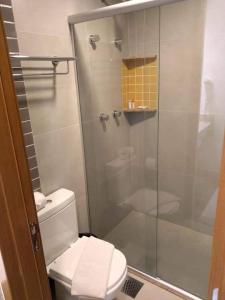 een badkamer met toilet en glazen douche bij Apartamento dentro de um Resort 6 in Olímpia