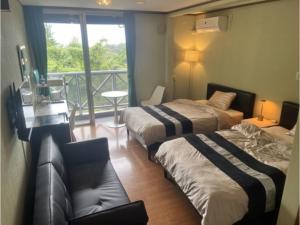 a hotel room with two beds and a balcony at Peace Inn Hagi - Vacation STAY 92117v in Hagi