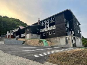 a black building with a parking lot in front of it at Peace Inn Hagi - Vacation STAY 92109v in Hagi