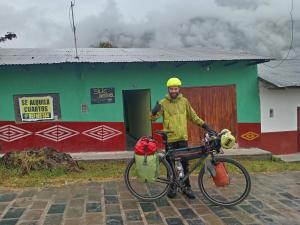 a man standing next to a bike in front of a building at Silic Hostel Camping in Nuevo Tingo