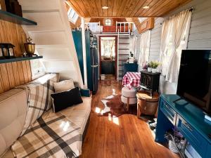 uma sala de estar de uma pequena casa com um sofá em Chalé europeu com vista infinita e cinema em C. do Jordão em Campos de Jordão