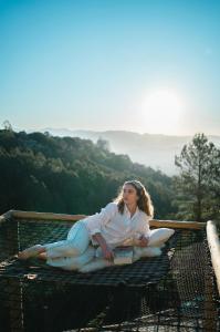 uma mulher está sentada em cima de uma gaiola em Chalé europeu com vista infinita e cinema em C. do Jordão em Campos de Jordão