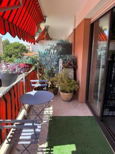 a patio with a table and chairs and potted plants at Superbe appartement avec piscine et parking in Fréjus