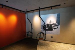 a room with two chairs and a picture of a car on the wall at La Tambra - Hotel Lodge in Santa Cristina in Val Gardena +94 photos