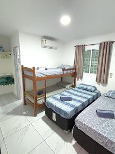 a room with two beds and a bunk bed at Espaçosos Aptos em Porto de Galinhas - Condominio com Piscina - Perto de tudo! in Porto De Galinhas