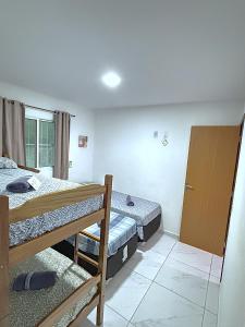 a bedroom with two bunk beds and a window at Espaçosos Aptos em Porto de Galinhas - Condominio com Piscina - Perto de tudo! in Porto De Galinhas
