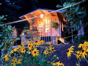 a small house with yellow flowers in front of it at Creekside Bunkies in Roberts Creek
