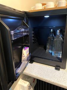 an open refrigerator with two bottles of water in it at Amma Jóna rooms in Ásólfsskáli