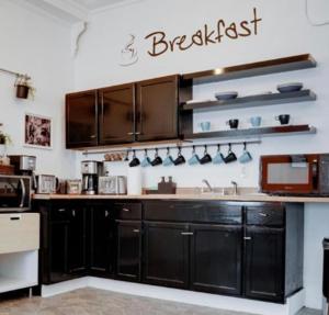a kitchen with black cabinets and a sign on the wall at Hola - Brickell- Bayside Wynwood - Downtown - WiFi - Female Dorms and Male Dorms - No Mixed in Miami