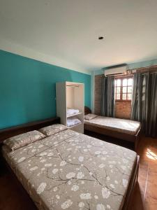a bedroom with two beds and a blue wall at Departamneto 1er Piso-Costa del Potiy in Encarnación