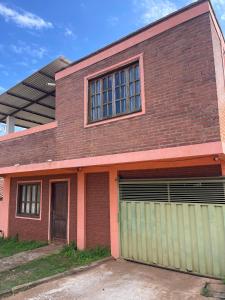 a brick building with two garage doors and a window at Departamneto 1er Piso-Costa del Potiy in Encarnación