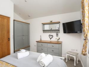 a bedroom with a bed and a flat screen tv at Cosy Cottage in Menai Bridge