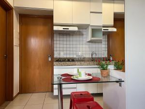 una piccola cucina con un tavolo e sgabelli rossi di Stúdio Next, Lago Norte a Brasilia