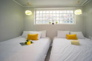 2 camas individuales en una habitación con almohadas amarillas en StaySolar, en Seúl