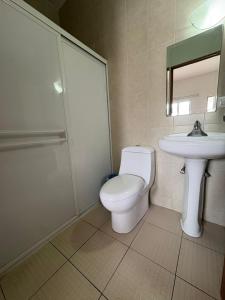 a bathroom with a toilet and a sink at Bugambilias Hotel Hacienda in Durango