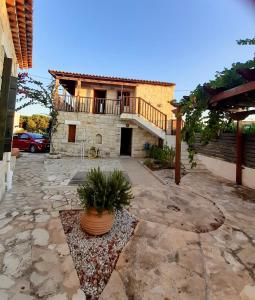 a stone house with a balcony and a patio at "Spiti Kolet", magnifique villa en bord de plage in Stavros +7 photos