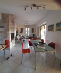 a living room with a table and red chairs at "Spiti Kolet", magnifique villa en bord de plage in Stavros