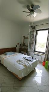a bedroom with a bed and a ceiling fan at "Spiti Kolet", magnifique villa en bord de plage in Stavros