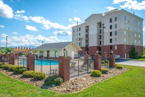a fence with a pool in front of a building at River Crossing Condominiums - A Beautiful River View in Pigeon Forge