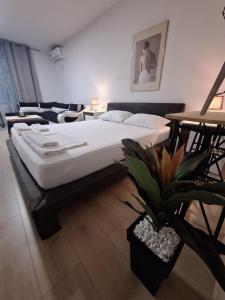 a bedroom with a large bed and a potted plant at Villa Srna Apartments in Brazda