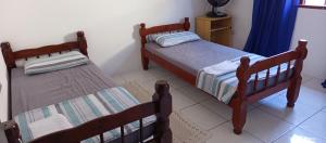 two beds sitting in a room with at Oásis Flórida in Peruíbe
