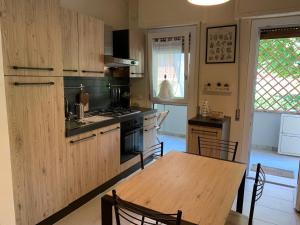a kitchen with a wooden table and a table and chairs at Gardenia Guest House in Marina di Massa