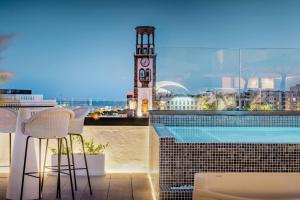 un edificio con una torre de reloj y una piscina en AC Hotel by Marriott Tenerife, en Santa Cruz de Tenerife