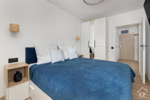 a bedroom with a blue bed with white walls at Apartament BEATA 102 Dziwnówek 200m od plaży EPapartamenty in Dziwnówek