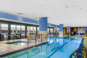 a large swimming pool in a hotel with blue walls and windows at Plaza 505 in Ocean City