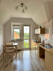 a kitchen with a table and a dining room at Apartament Albion in Szklarska Poręba