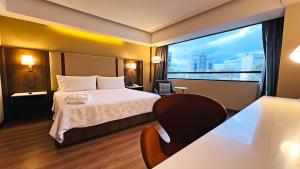 a hotel room with a bed and a large window at Holiday Inn Mexico City-Plaza Universidad by IHG in Mexico City +85 photos
