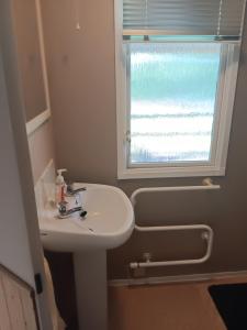 a bathroom with a sink and a window at Hendre Glamping- Caravan Bryngwyn in Boncath +17 photos