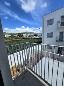 a balcony with a white railing and a building at Lagoa Nest in Lagoa