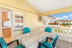 une salle à manger avec une table et des chaises et un balcon dans l'établissement Apartment Draga, à Vir