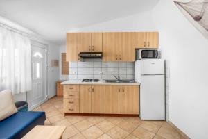 a kitchen with wooden cabinets and a white refrigerator at Apartment Draga in Vir