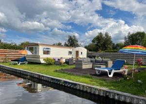 a caravan sitting next to a body of water at Houseboatvinkeveen Lelie in Vinkeveen