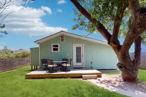 een huis met een tafel en stoelen in de tuin bij Flip Flop Cottage in Rockport