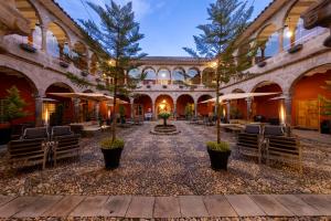 a courtyard with chairs and trees in a building at Wyndham Costa del Sol Cusco in Cusco