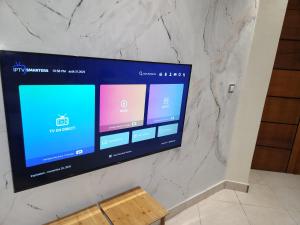 a flat screen tv on a marble wall at E1G Meublé 1CH in Douala