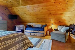 a bedroom with a bed and a couch and a chair at Hager Cabin AND Loft in Aledo